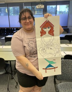 Person holds drawing from mural workshop