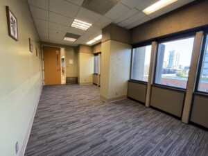 A large unfurnished room with a carpeted floor and big windows